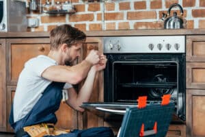 repairman fixing oven